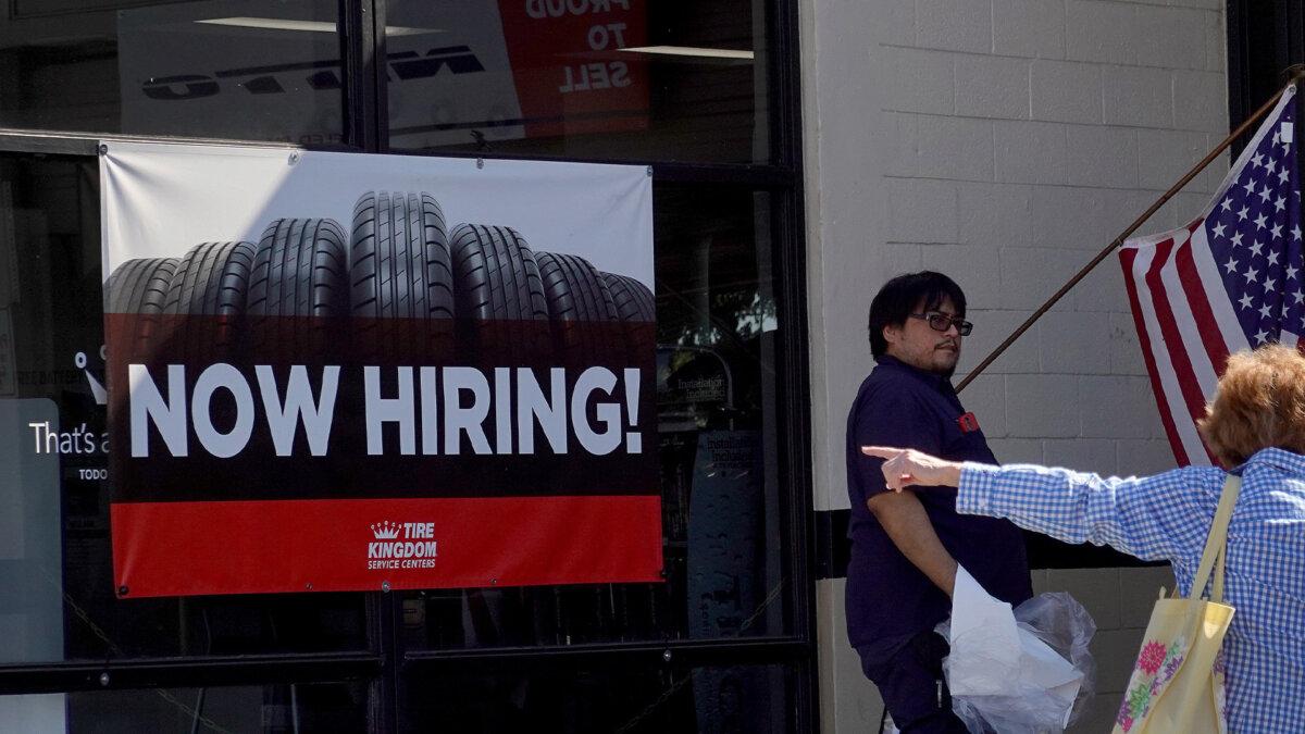 A Now Hiring sign hangs at a Tire Kingdom store in Miami on Dec. 3, 2021. (Joe Raedle/Getty Images)