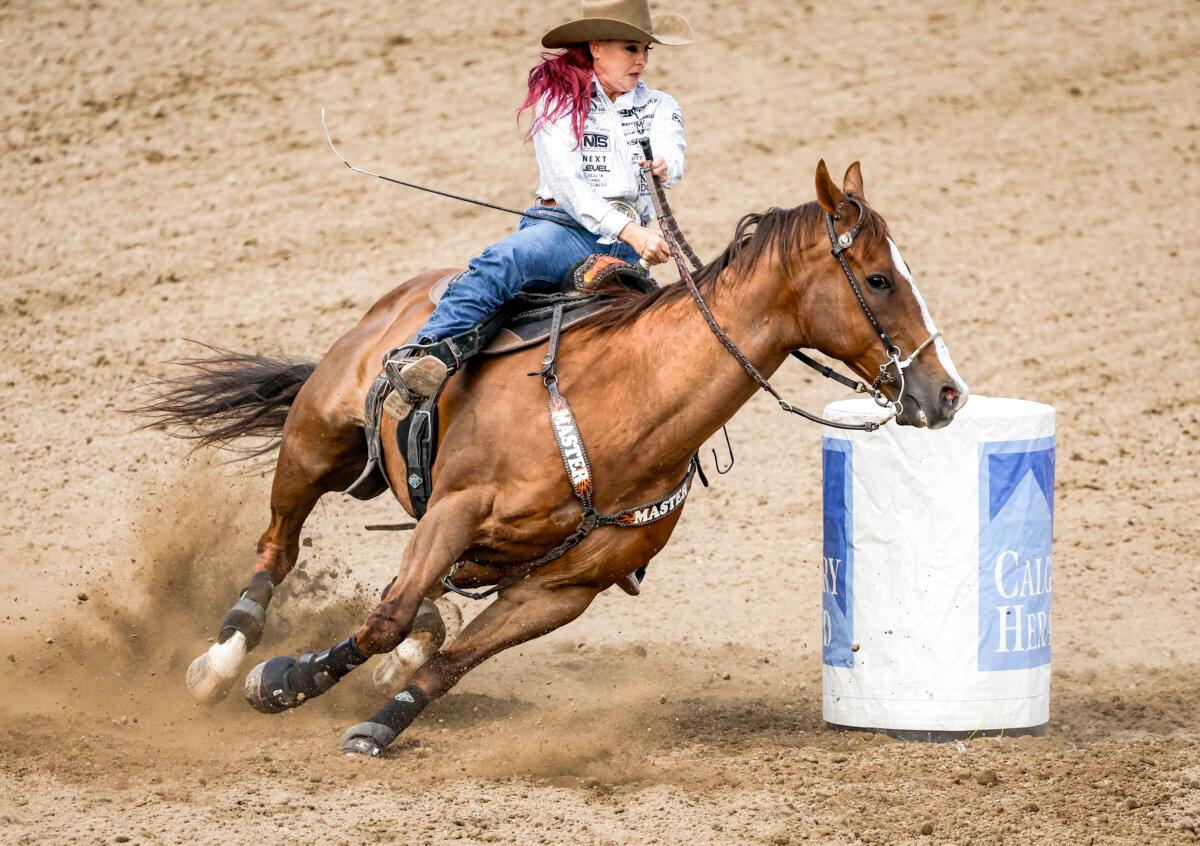 Leslie Smalygo, of Skiatook, Okla., races to victory during barrel racing rodeo finals at the Calgary Stampede in Calgary on July 14, 2024. (The Canadian Press/Jeff McIntosh)
