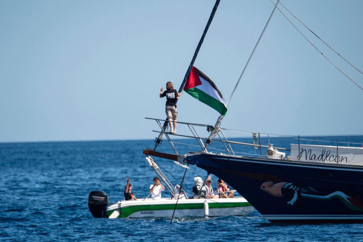 Climate activist Greta Thunberg stands near a Palestinian flag on the sailboat Madleen in the port of Catania, Italy, on June 1, 2025. (Salvatore Cavalli/AP Photo)
