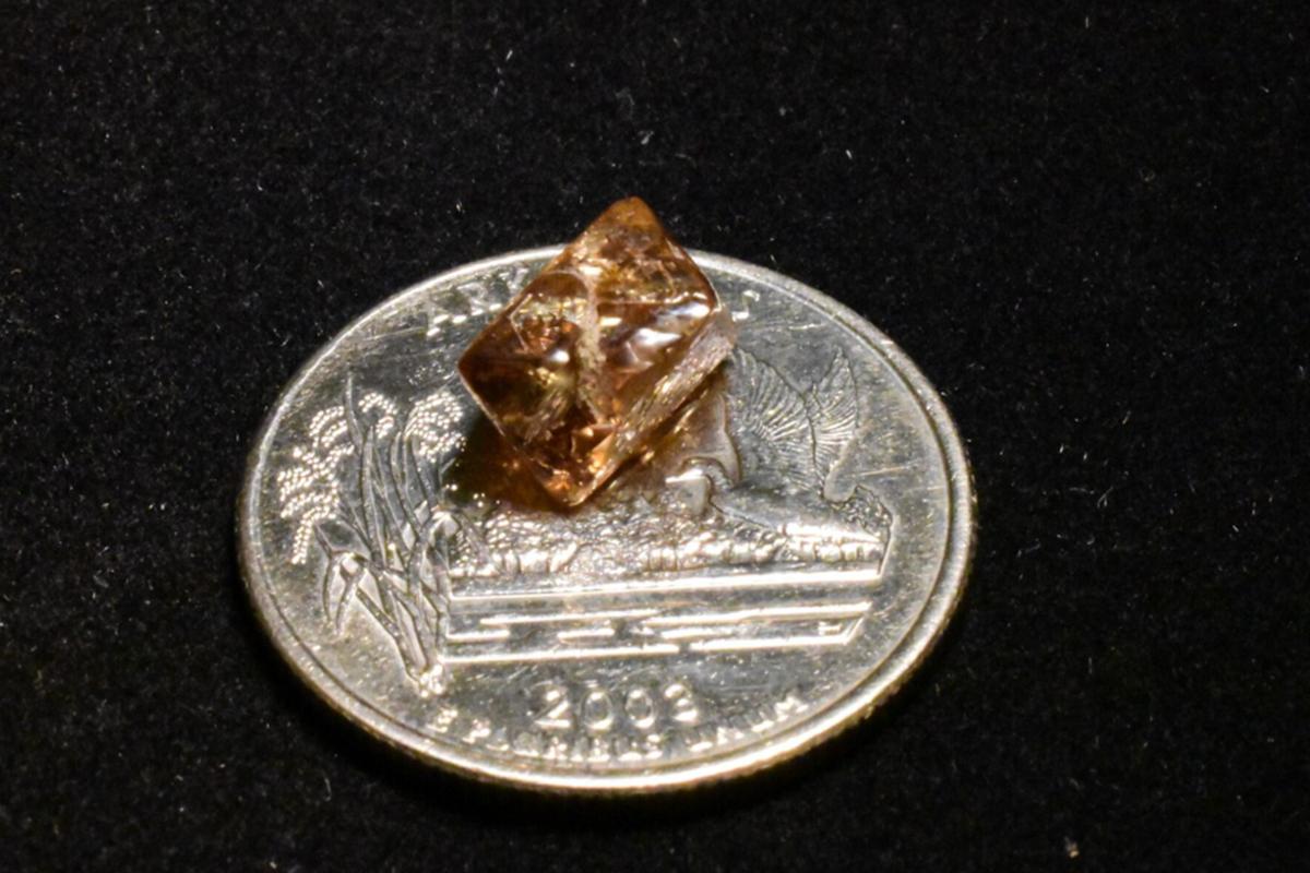 The Duke Diamond sparkles atop an Arkansas coin. (Courtesy of Crater of Diamonds State Park)