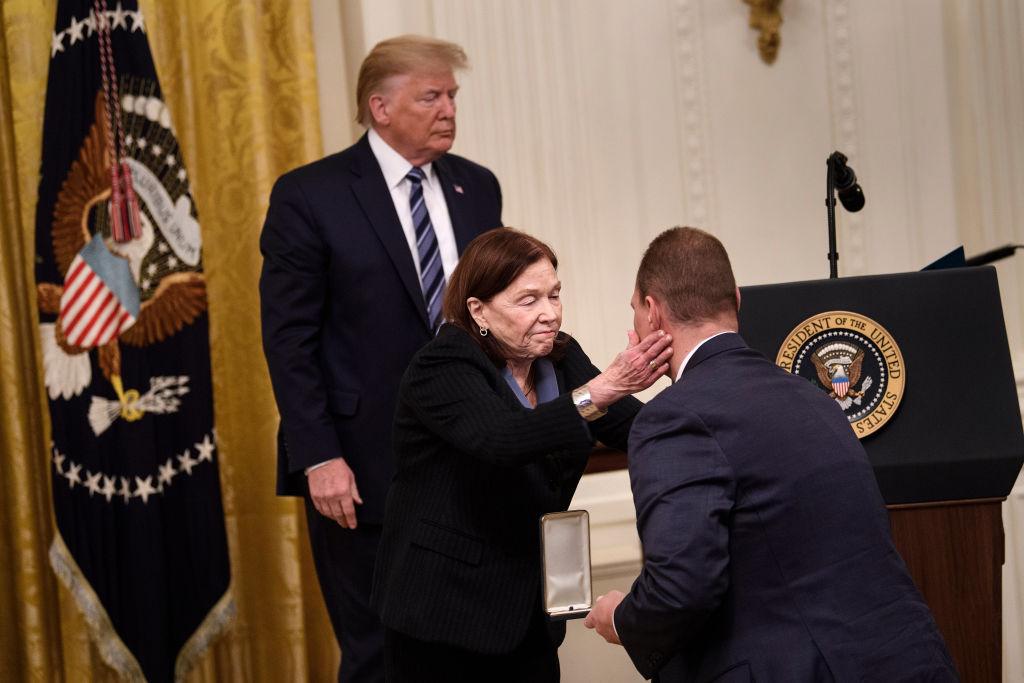 President Donald Trump stands by as Susan Rescorla gives her son, Trevor Rescorla, the Presidential Citizens Medal, posthumously given to her late husband Rick Rescorla at the White House on Nov. 7, 2019. (Brendan Smialowski / AFP via Getty Images)