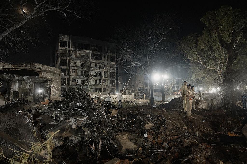 Security guards stand watch at the crash site of the doomed Air India flight on June 12, 2025 in Ahmedabad, India. The aircraft crashed into the densely populated Meghani Nagar area, resulting in a massive explosion and fire due to the heavy fuel load for the international journey, with rescue operations ongoing. (Photo by Elke Scholiers/Getty Images)