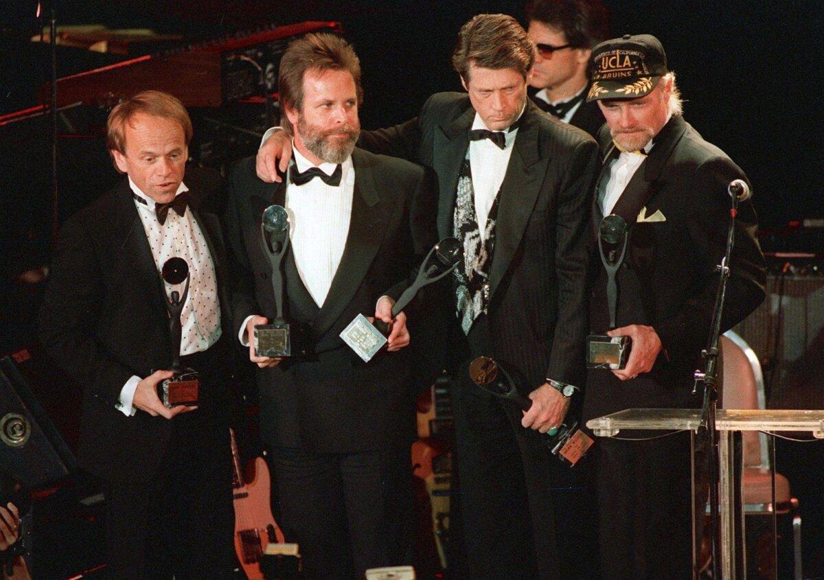 (L-R) Beach Boys Al Jardine, Carl Wilson, Brian Wilson, and Mike Love hold their trophies after being inducted into the Rock ‘n’ Roll Hall of Fame in New York on Jan. 21, 1988. (AP Photo/Ron Frehm)