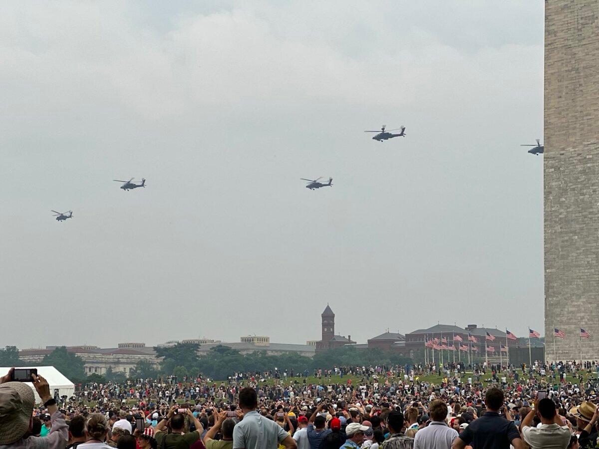 Spectators watch helicopters during a parade marking the 250th birthday of the Army in Washington on June 14, 2025. (Epoch Times)