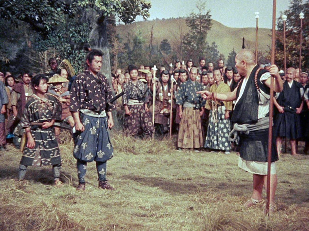 Pupil Jotaro (Kenjin Iida) looks on as his master, Musashi Miyamoto (Toshiro Mifune), tries to avoid a fight with an ornery monk, in “Samurai III: Duel at Ganryu Island.” (Toho)