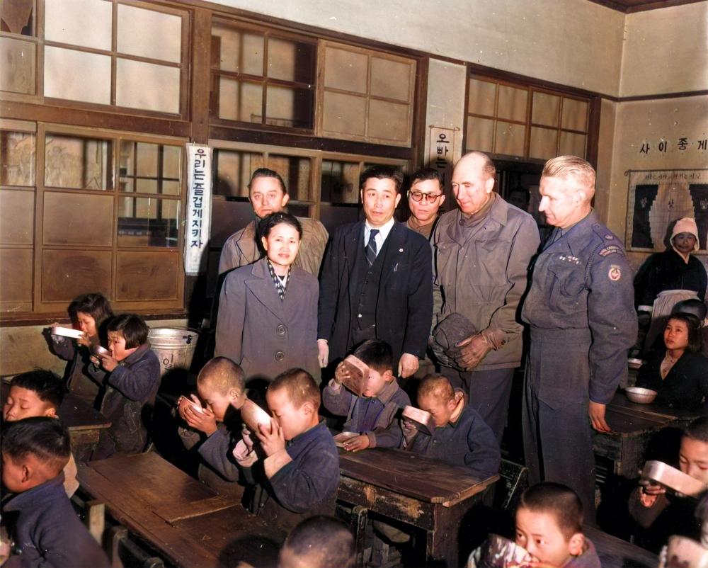 Officials from the United Nations Civil Assistance Command Korea (UNCACK) observe milk being distributed to children at Gongdeok Elementary School in Mapo-gu, Seoul, South Korea, on Feb. 12, 1953. (Courtesy of Ahn Jae-chul, president of The World Peace Freedom United)