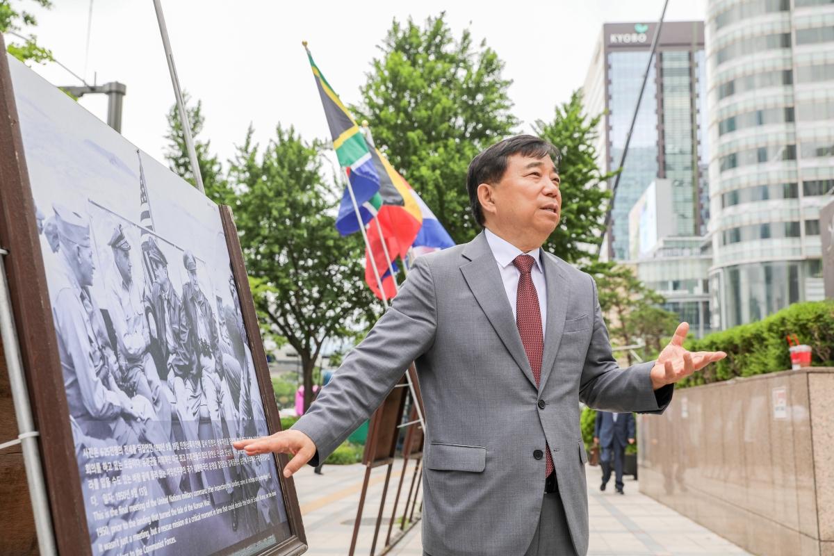 Ahn Jae-chul, president of The World Peace Freedom United (WPF), explains a photo on display during the Korean War Photo Exhibition in downtown Seoul, South Korea, on June 10, 2024. The photo shows the UN Command leadership holding a final meeting on Sept. 15, 1950, just before the Incheon Landing Operation. Ahn said “It was a moment of rescue at a critical turning point that determined the fate of the Republic of Korea (South Korea), a free democratic nation on the brink of being completely lost to communists.” (Han Ki-min/The Epoch Times)