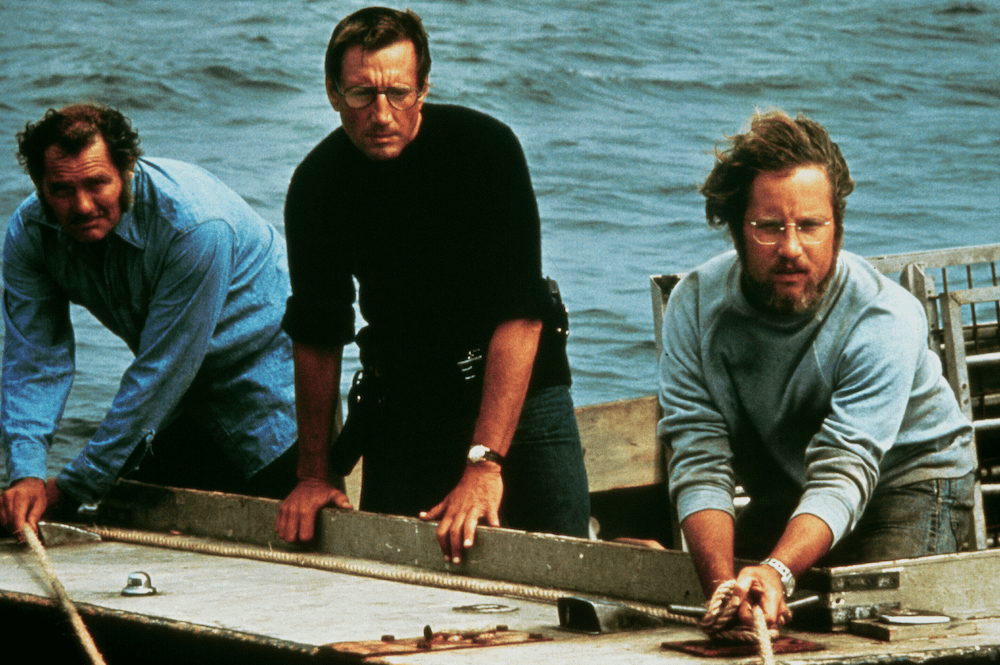 (L–R) Quint (Robert Shaw), Brody (Roy Scheider), and Hooper (Richard Dreyfuss) go shark fishing, in "Jaws." (Universal Pictures)