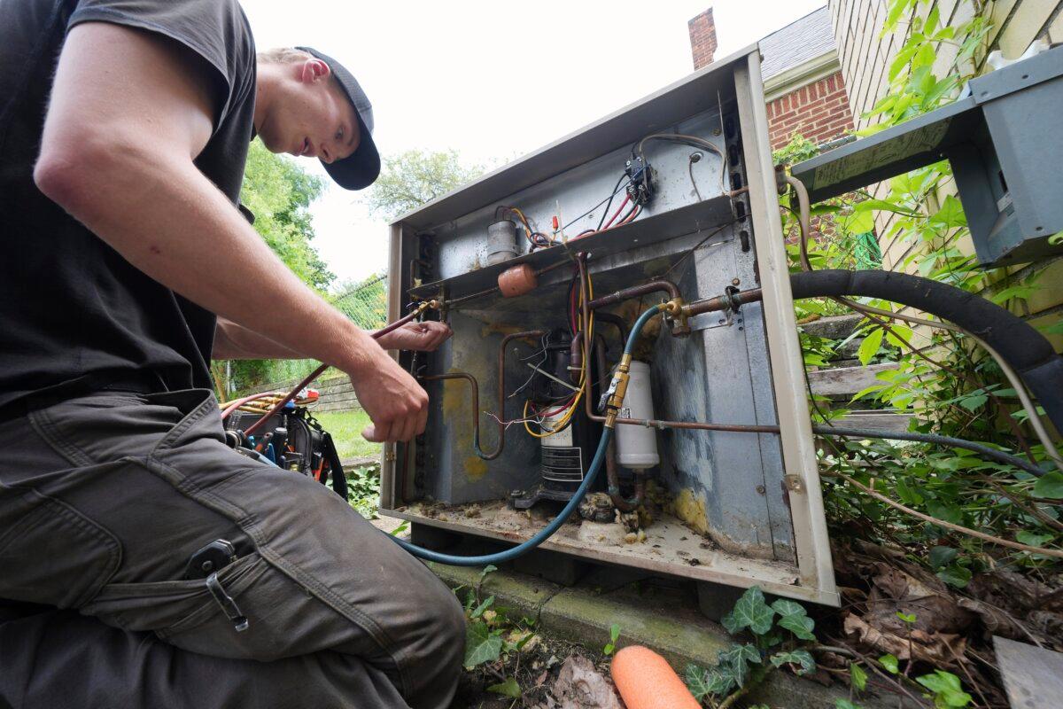 An HVAC technician replaces an air conditioning unit outside a home in Greenfield, Pa., on June 21, 2025. (Gene J. Puskar/AP Photo)
