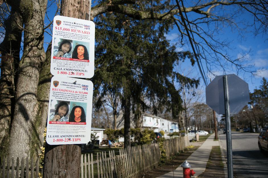 A sign offering a reward for information about the murders of Nisa Mickens and Kayla Cuevas, near Brentwood High School in Brentwood, Suffolk County, N.Y., on March 29, 2017. (Samira Bouaou/The Epoch Times)