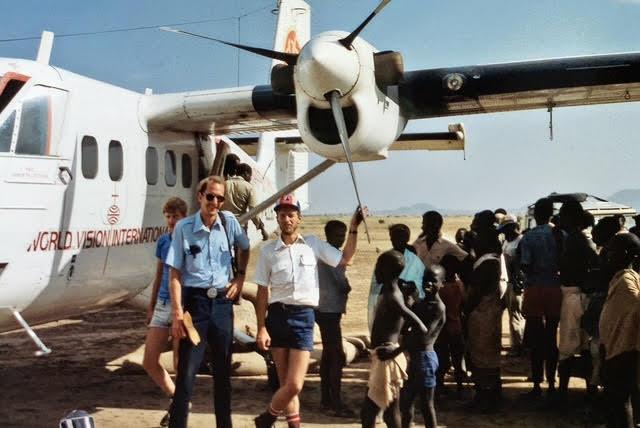 William Rew, in the white shirt, stands next to the Twin Otter aircraft he used to fly aid missions in Ethiopia, in 1984. (Provided by MAF)