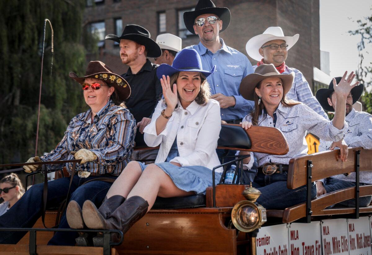 Alberta Premier Danielle Smith (C) waves from a float during the Calgary Stampede parade on July 4, 2025. (The Canadian Press/Jeff McIntosh)