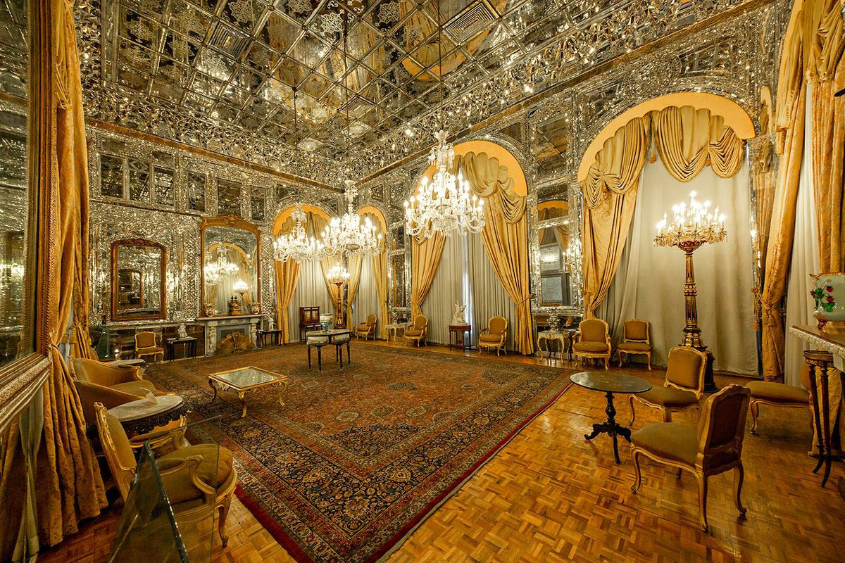 The Hall of Mirrors, renowned for its stunning mirror mosaics that cover the walls and ceiling, is one of the most famous halls in Golestan Palace. Designed by Sanie-ol-Molk, the exquisite mosaic is a prime example of <a href="https://makezine.com/article/craft/heirloom-tech-aineh-kari-next-level-mirror-mosaics/" target="_blank" rel="nofollow noopener">aineh-kari</a>, an intricate art that combines mirror mosaics with traditional Persian craftsmanship. Aside from the mirrors and the Persian carpet, the room is reminiscent of European Baroque aesthetics with its ornate furnishings and 17th-century French parquet floors. (MehmetO/Shutterstock)