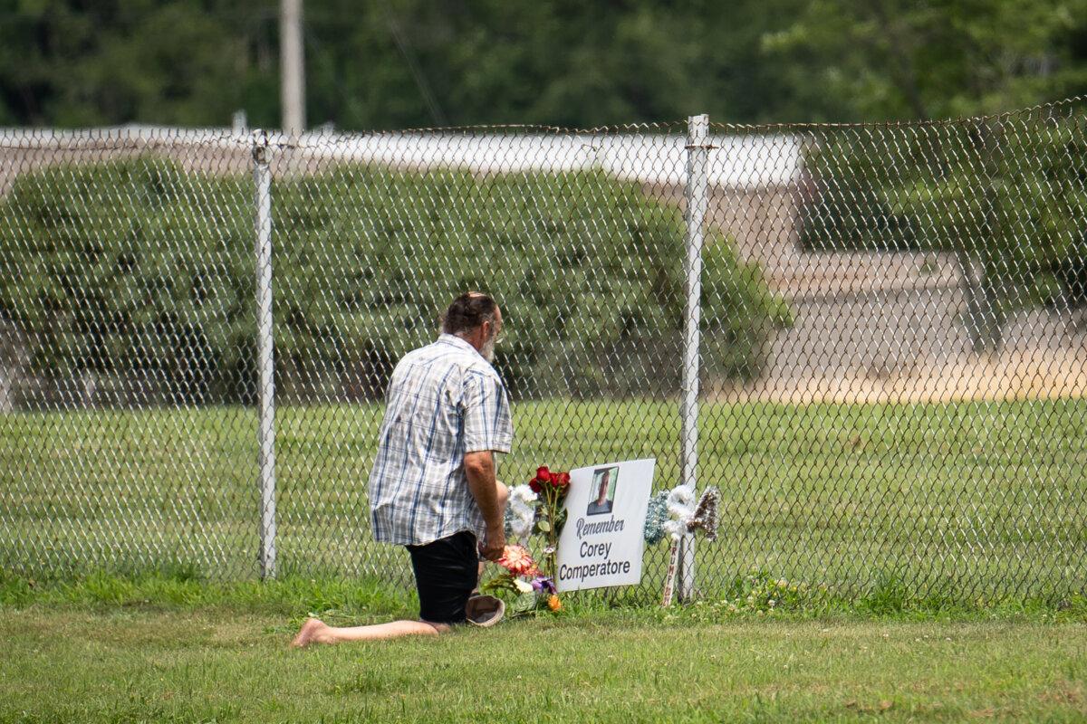 Shawn Morin lays flowers at a memorial for Corey Comperatore in Butler County, Pa., on July 13, 2025. (Samira Bouaou/The Epoch Times)