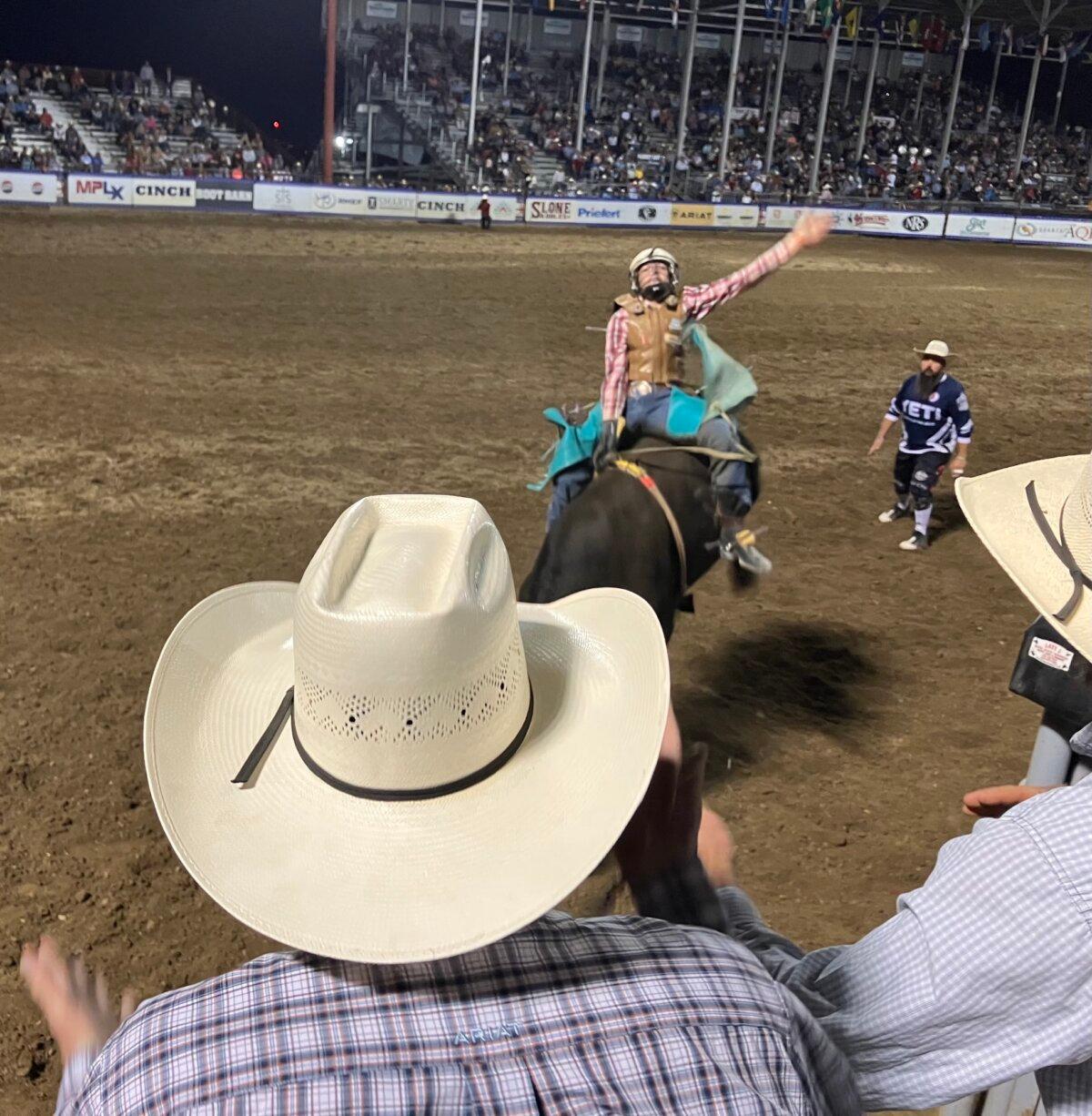 Jock Maxwell, 16, of Pinkett, New South Wales, Australia, is dumped by a bull in 3.4 seconds, short of the required eight-second ride, eliminating him from the National High School Finals Rodeo in Rock Springs, Wyo., on July 16, 2025. (John Haughey/The Epoch Times)