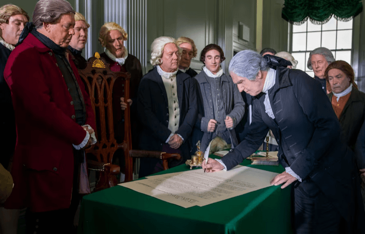 George Washington (Daniel H.T. Shippey) signs the American Constitution, in “The American Miracle: Our Nation Is No Accident.” (Heroic Pictures/Fathom Entertainment)