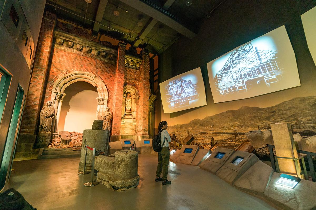 A visitor observes historical footage at the Nagasaki Atomic Bomb Museum. (f11photo/Shutterstock)