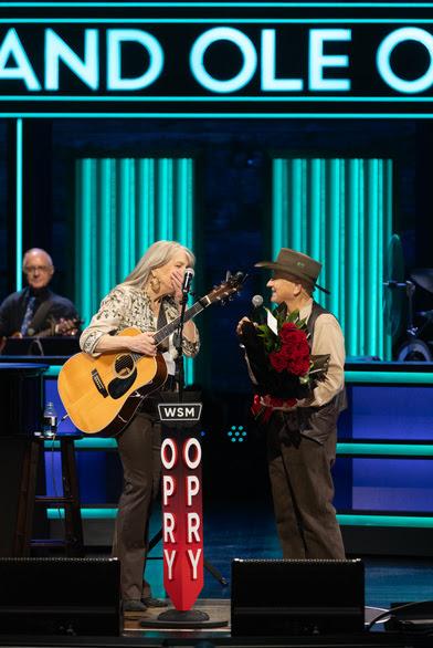 Kathy Mattea is surprised onstage with an invitation from Opry member Charlie McCoy to become a member of the Grand Ole Opry. (Courtesy of the Grand Ole Opry)