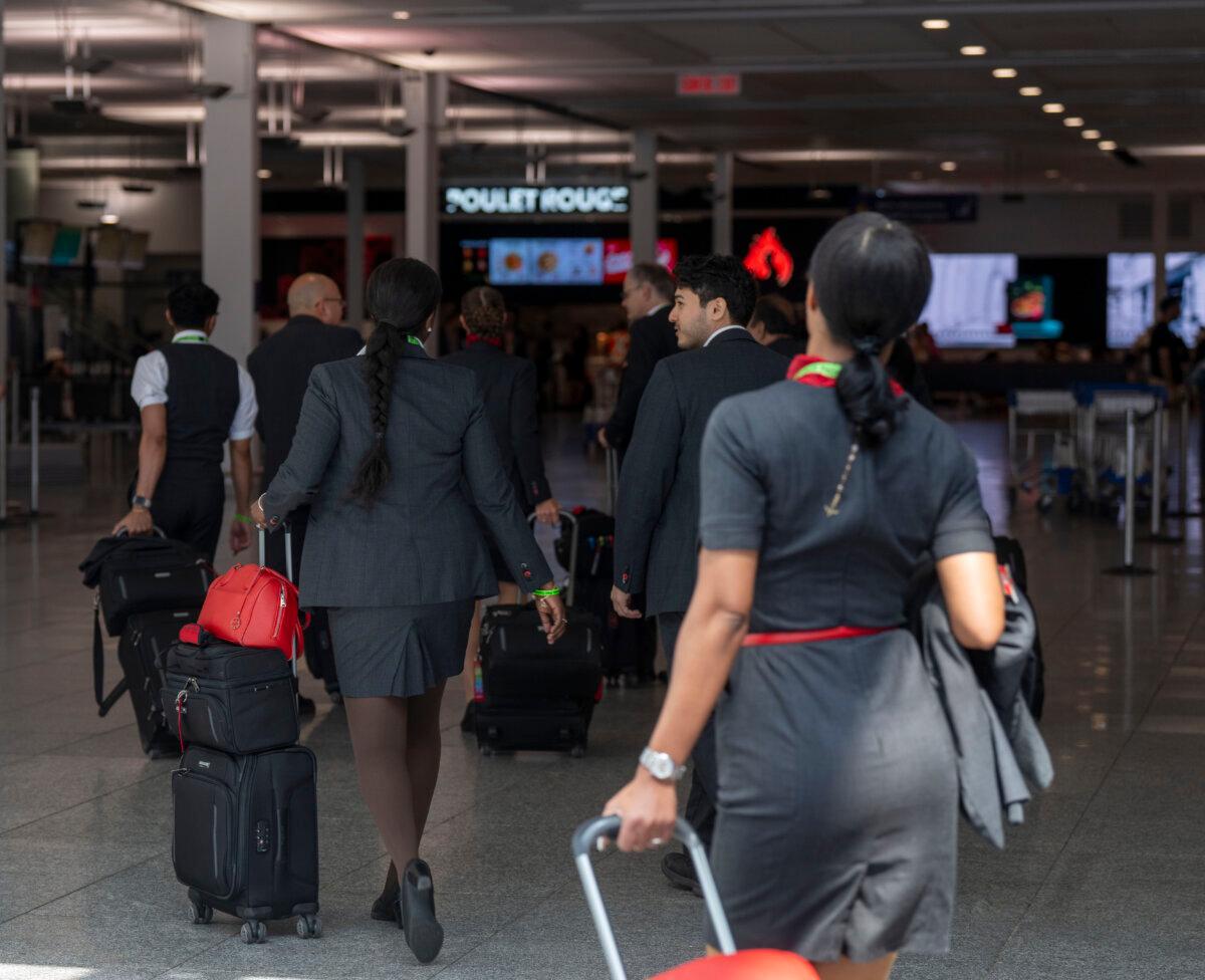 Air Canada flight attendants walk through the Montreal-Pierre Elliott Trudeau International Airport in Dorval, Que., on Aug. 15, 2025. (The Canadian Press/Christinne Muschi)