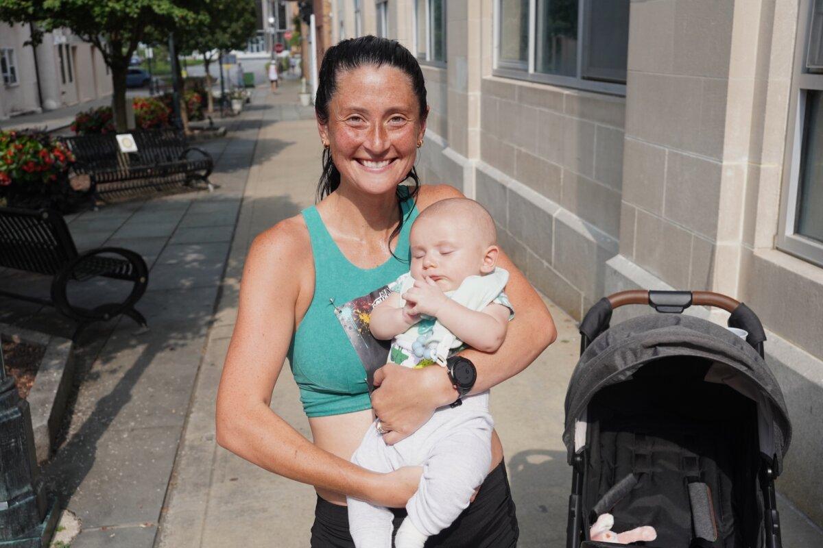First place women's runner Skylar Musa with her baby after the Run 4 Downtown race in Middletown, N.Y., on Aug. 16, 2025. (Oliver Mantyk/The Epoch Times)
