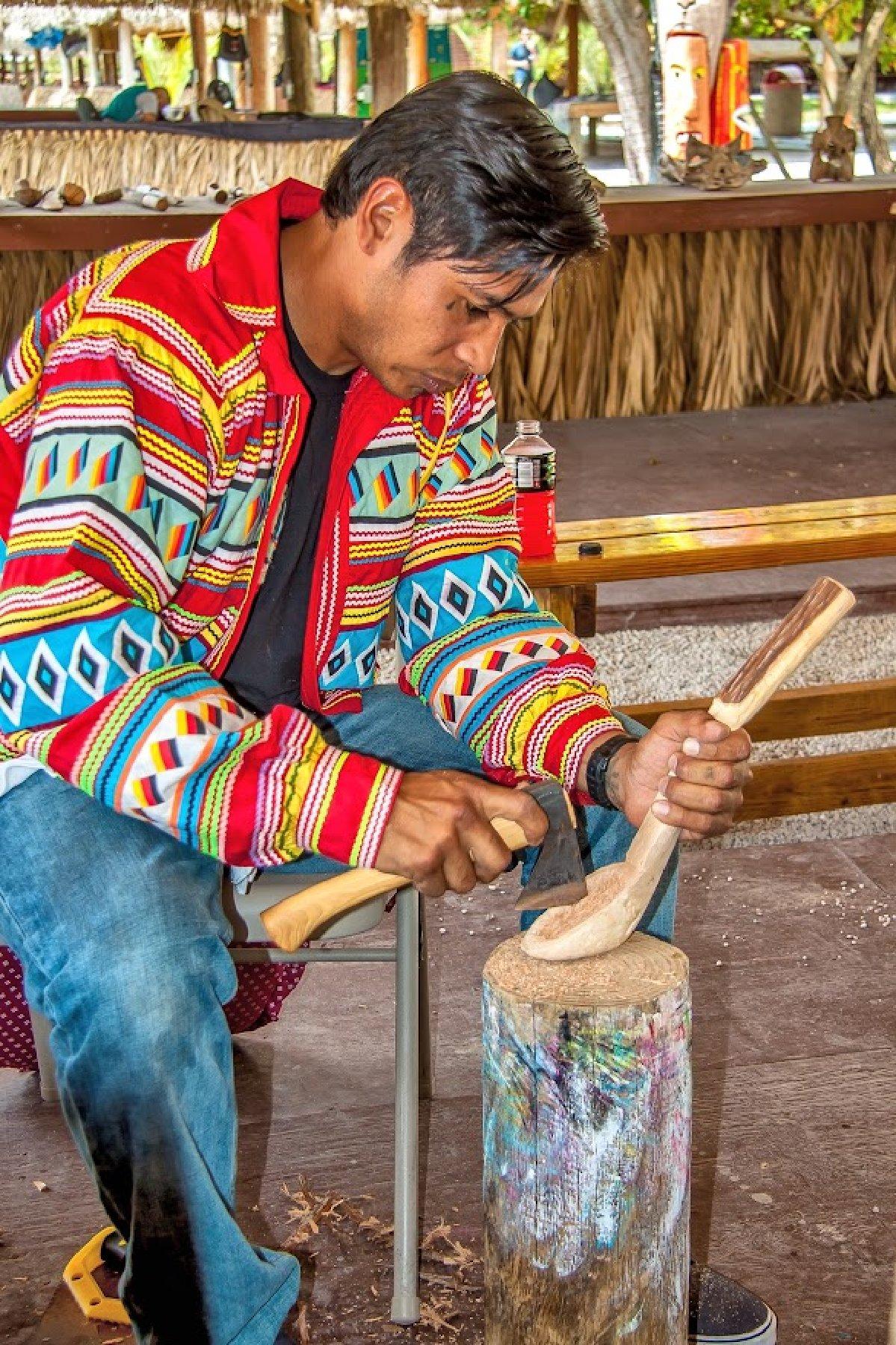 A Miccosukee man demonstrates carving a wood cooking utensil at Miccosukee Indian Village on the edge of Everglades National Park in Florida. (Rudy Umans/Dreamstime)