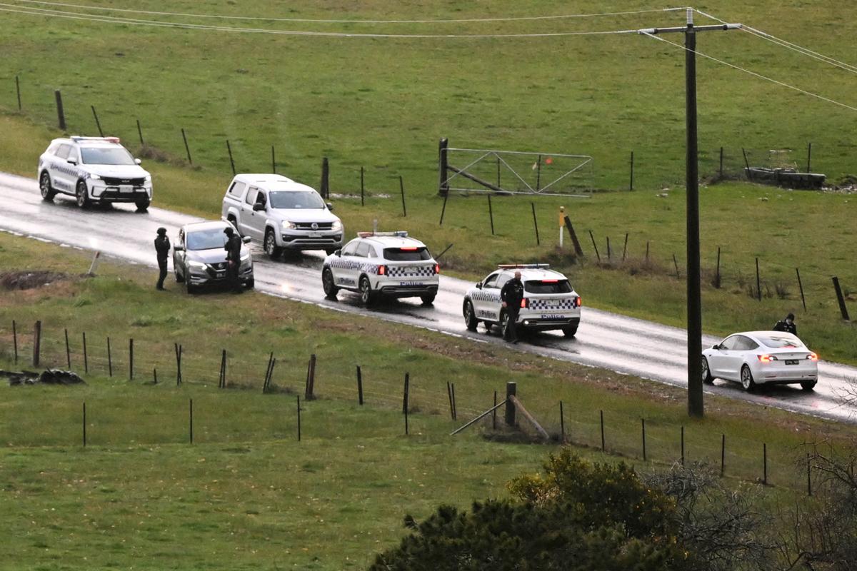 TOPSHOT - Police and sniffer dogs man a road block during the search for a fugitive linked to the murder of two police officers in Porepunkah, Australia on Aug. 29, 2025. (William West/AFP via Getty Images)
