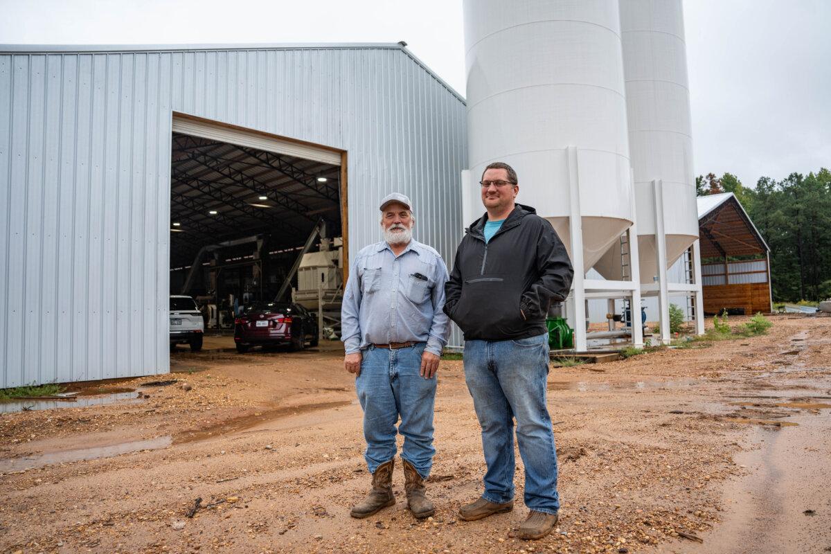Father and son partners at A&E Pellet Mills, Edwin (L) and Adam Rogers, near Stamps, Ark., on Sept. 24, 2025. They have invested $4 million in building two 60-by-240-foot plants to churn “chicken litter” into pellets they say are easier for farmers to use as fertilizer than spraying and won’t leach nitrogen into streams and bayous. (Samira Bouaou/The Epoch Times)