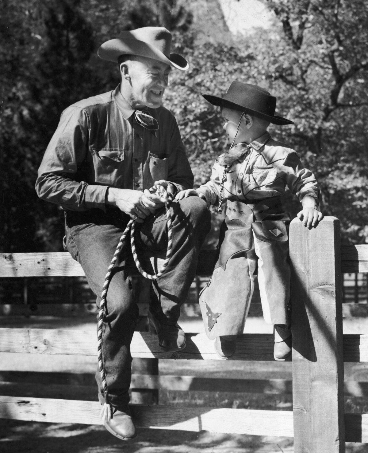 A cowboy demonstrates knot tying to a little boy, circa 1945. (Ralph Hopewell Anderson/Hulton Archive/Getty Images)