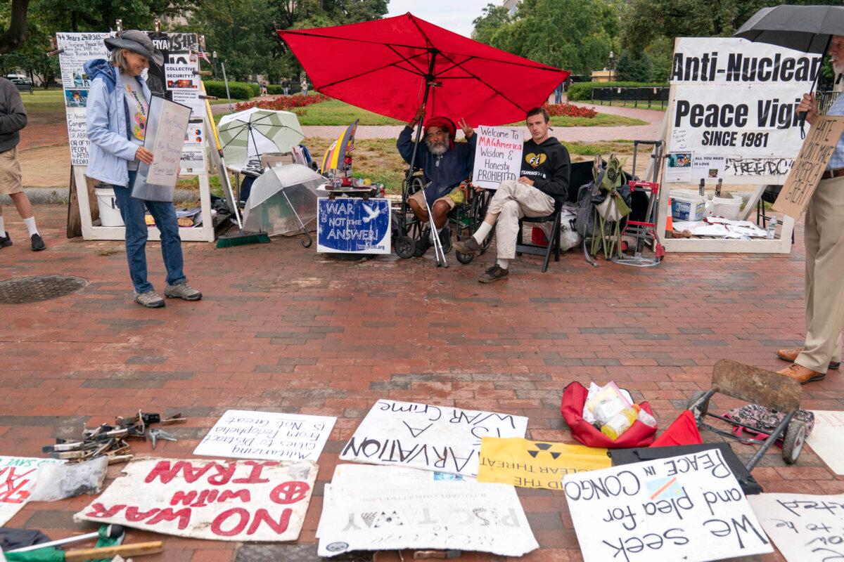 Philipos Melaku-Bello (center L) and Will Rosin (center R) flash the V sign during Peace Vigil in Lafayette Park across from the White House in Washington, on Sept. 7, 2025. (Jose Luis Magana/AP Photo)