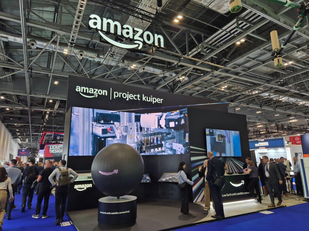 People walk past Amazon's Project Kuiper—a constellation of Low Earth Orbit satellites—display stand at the DSEI exhibition at Excel in London on Sept. 10, 2025. (Chris Summers/The Epoch Times)