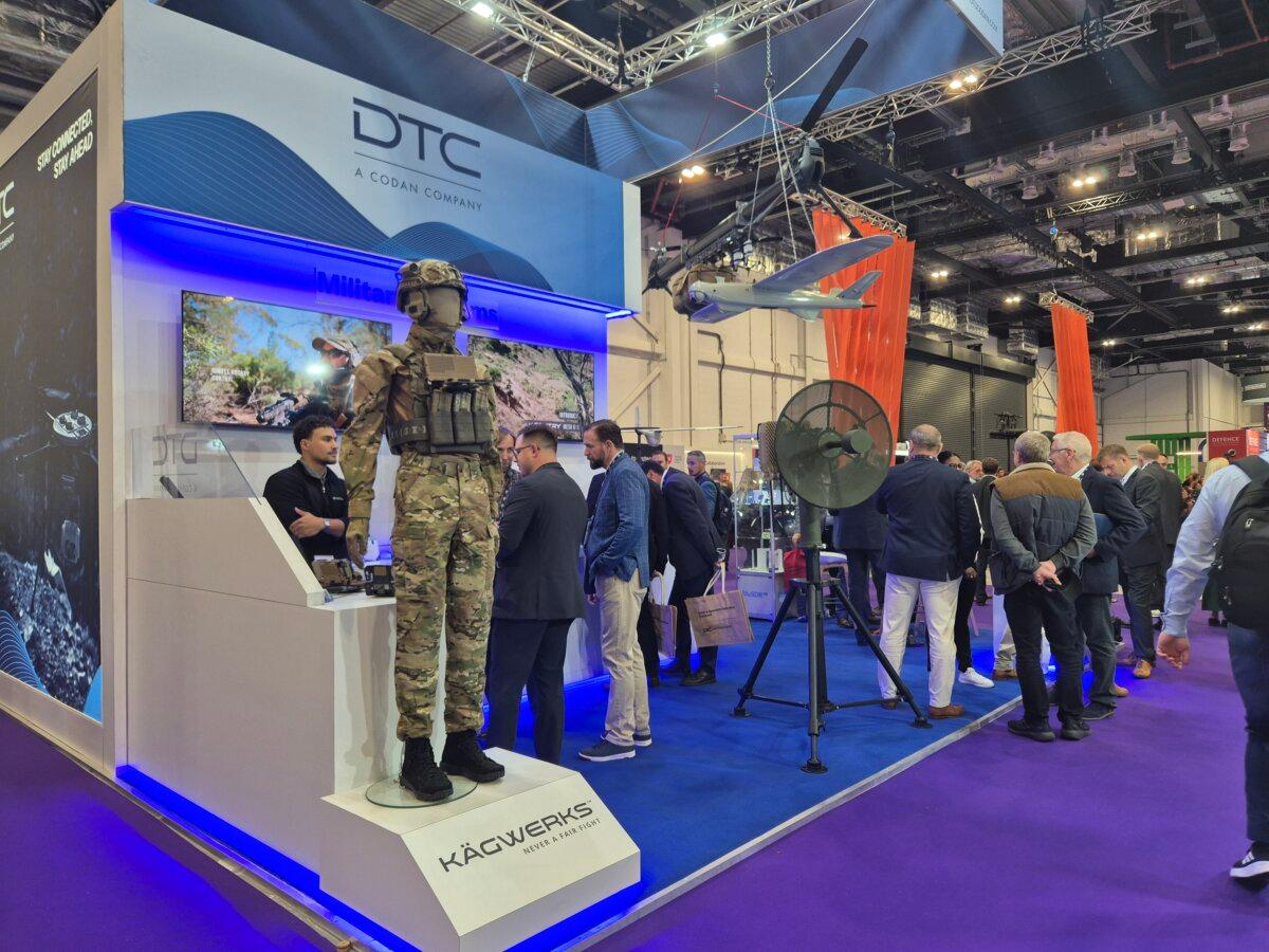 People at the stands of defense tech companies DTC and Kägwerks at the DSEI defense industry exhibition at ExCel in London on Sept. 10, 2025. (Chris Summers/The Epoch Times)