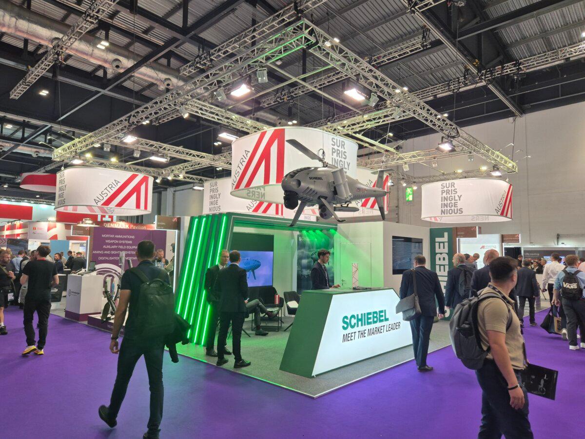 A man walks past the stand of Schiebel, an Austrian camcopter manufacturer, at the DSEI defense industry exhibition at ExCel in London on Sept. 10, 2025. (Chris Summers/The Epoch Times)