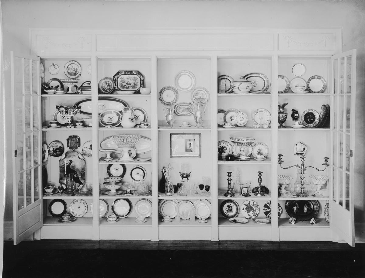 This circa 1920s image of a cabinet in the China Room shows various china and glassware displayed as if in a pantry. This method of exhibition later became unfeasible as the collection expanded. (White House Historical Association/White House Collection)