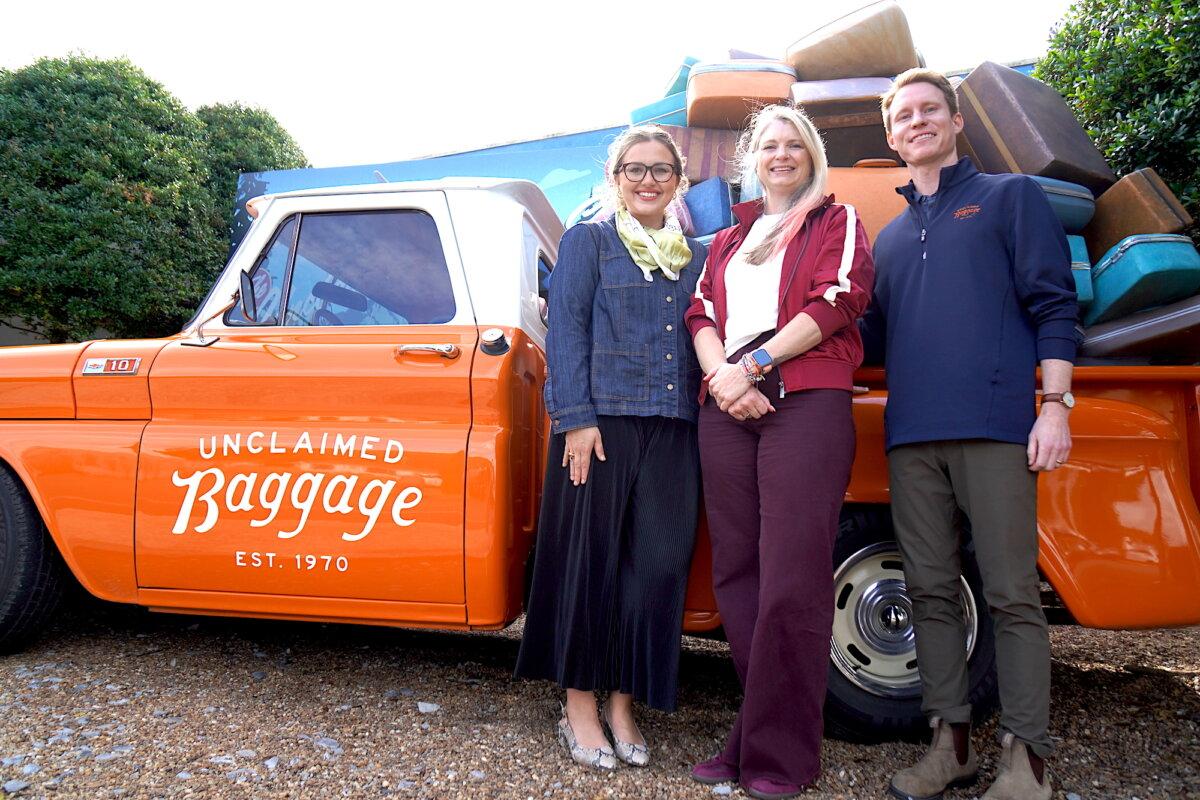 Unclaimed Baggage Senior Public Relations Manager Sonni Hood (L), Creative Director Michelle Parker (C), and Senior Vice President of Commercial Strategy Matt Owens (R) stand in front of the business's vintage pickup truck on Oct. 8, 2025. (Allan Stein/The Epoch Times)