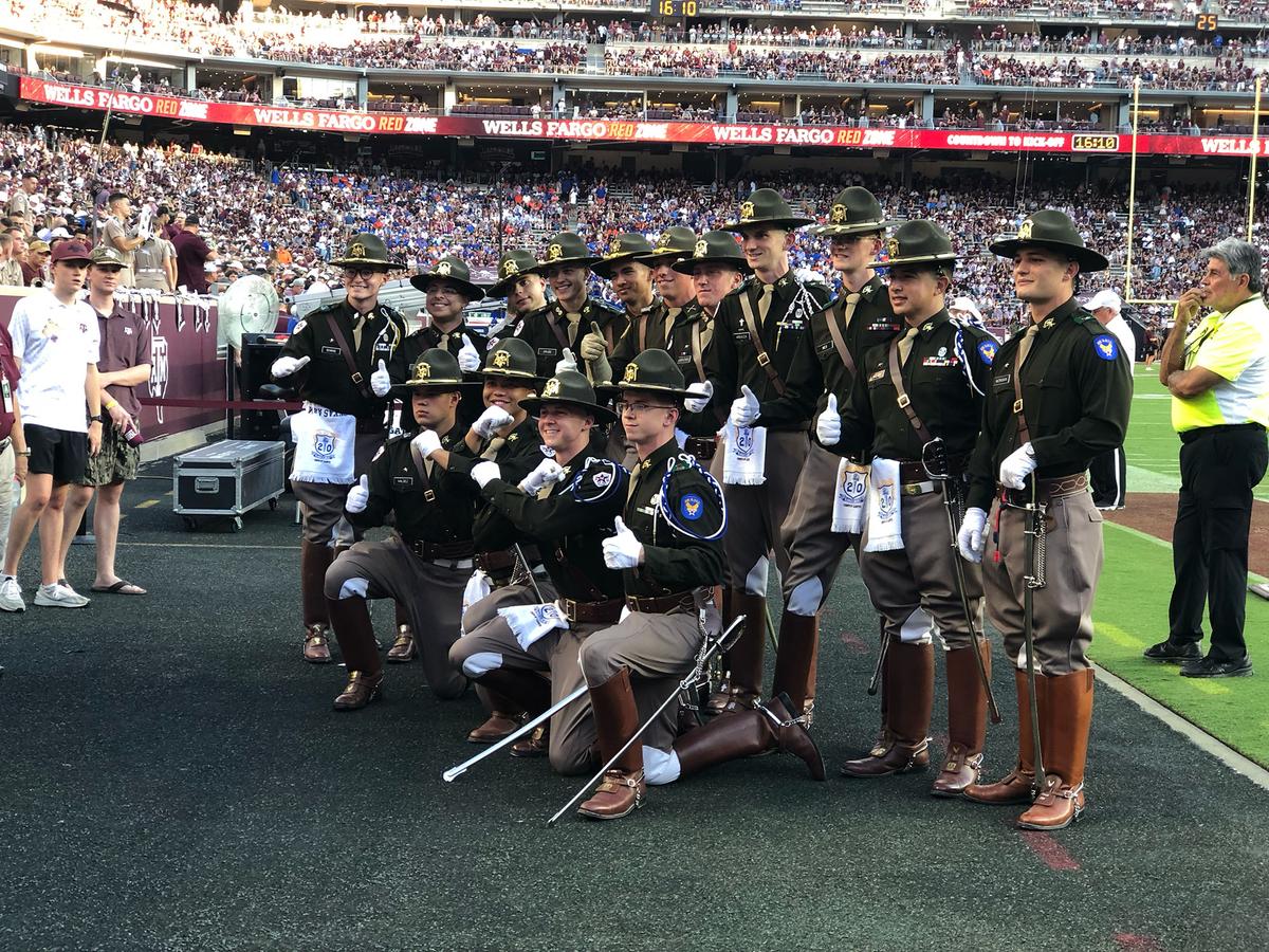 Cadets from the Texas A&M University Corps of Cadets give the thumbs-up "gig 'em" sign, which originated during a yell practice before an Aggie football game in the early 20th century. (Dustin Bass)