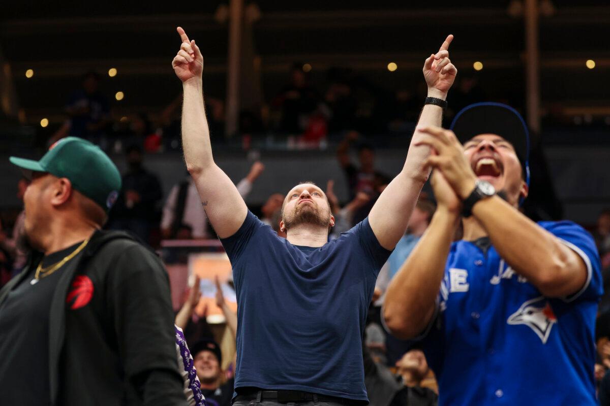 Baseball fans watch the Toronto Blue Jays and Los Angeles Dodgers World Series Game 1 displayed on the video board at Scotiabank Arena in Toronto on Oct. 24, 2025. (The Canadian Press/Nick Iwanyshyn)