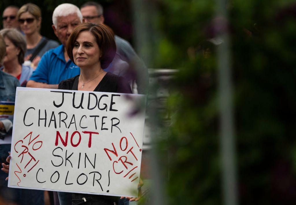 A woman holds up a sign during a rally against "critical race theory" (CRT) being taught in schools in Leesburg, Va., in 2021. (Andrew Caballero-Reynolds/AFP via Getty Images)