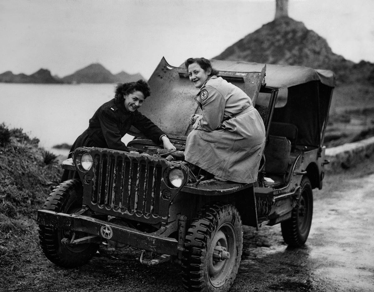 American military nurse Lieutenant Elizabeth Biller and American Red Cross worker Sylvia Rubin inspect under the hood of their U.S. Army jeep, which has stalled in the wet weather, during World War II, in Corsica, France, on April 7, 1944. ((Ollie Atkins/American Red Cross/FPG/Archive Photos/Getty Images)