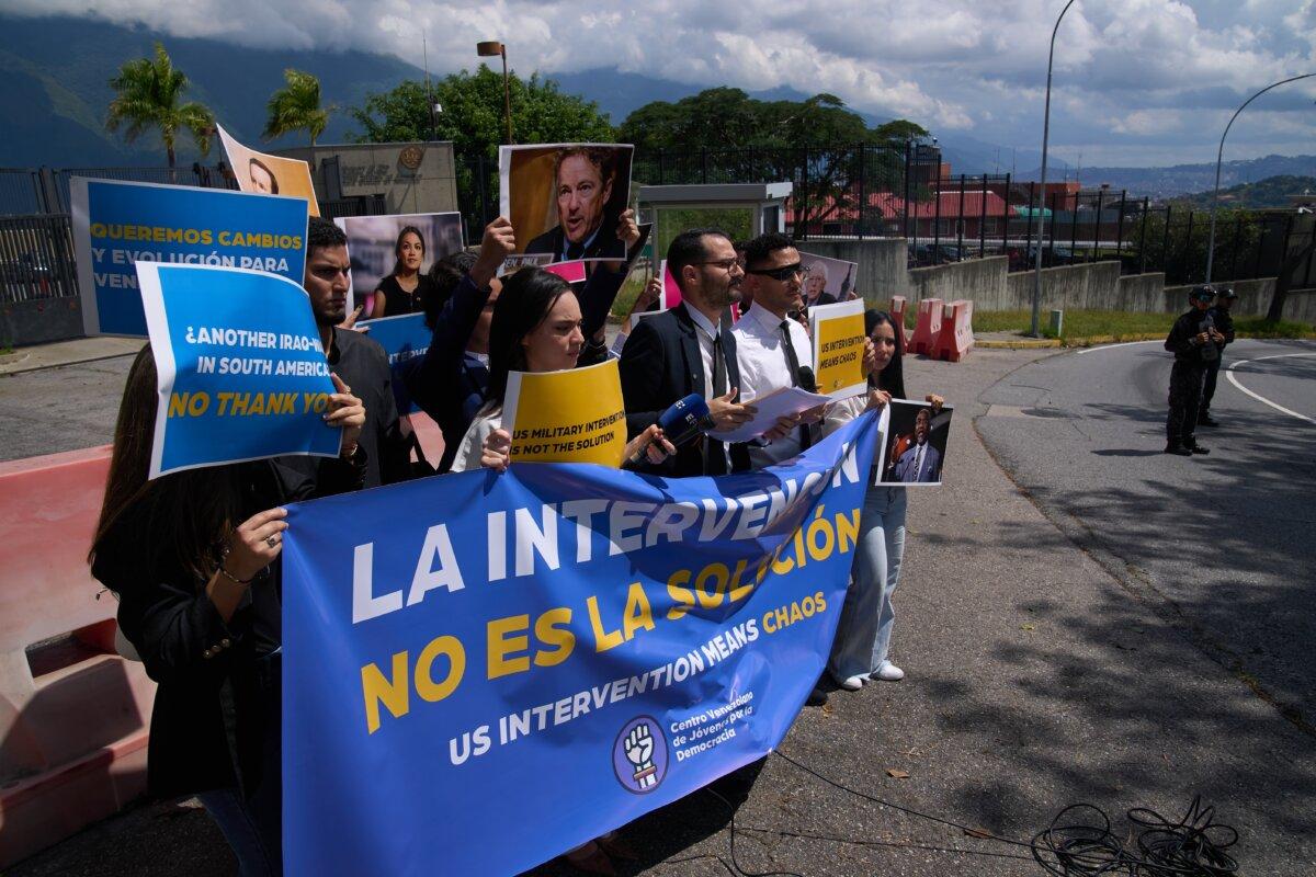 Gabriel Cabrera, president of the Venezuelan Youth Center for Democracy, gives a statement outside of the U.S. Embassy with members of the organization holding signs that read in Spanish "Intervention is not the solution," in reference to U.S. warships operating in the Caribbean, in Caracas, Venezuela, on Oct. 27, 2025. (AP Photo/Ariana Cubillos)