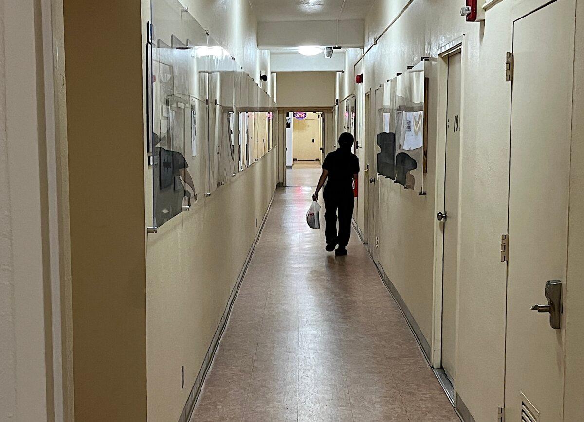 A resident of Begich Towers in Whittier, Alaska, walks past the post office inside the 14-story apartment building on Nov. 4, 2025. (Allan Stein/The Epoch Times)