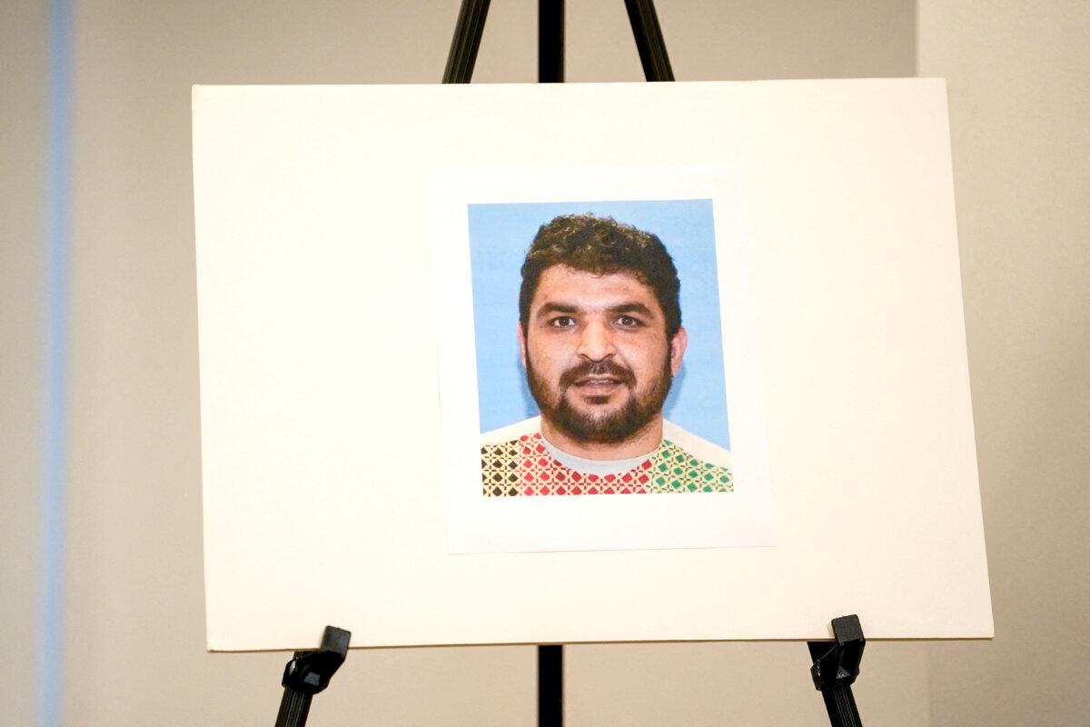 A picture of Rahmanullah Lakanwal, an Afghan national who is the suspect in the shooting of two National Guard members, is displayed at a press conference with FBI Director Kash Patel, attorney Jeanine Pirro, and other authorities, in Washington on Nov. 27, 2025. (Nathan Howard/Reuters)