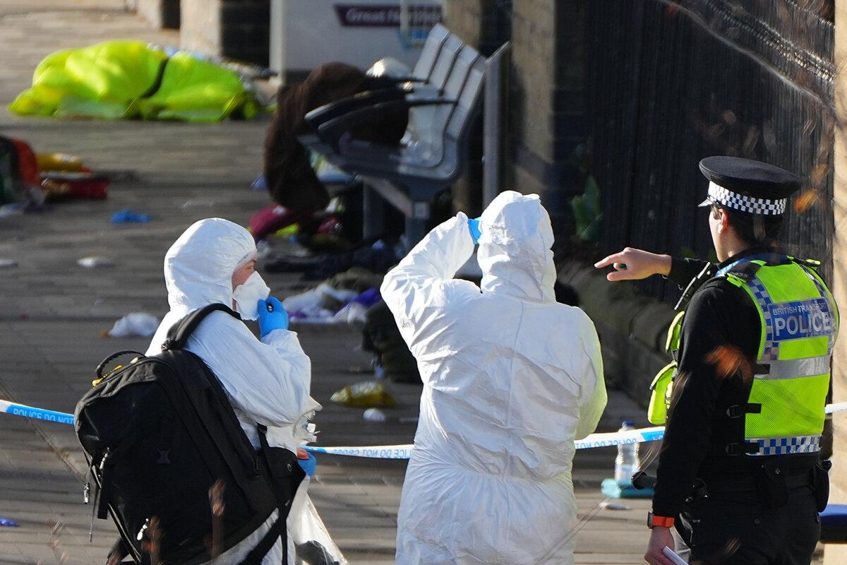Forensic investigators look at the area where travellers left their belongings after a mass stabbing on a London-bound train in Huntingdon, England, Sunday, Nov. 2, 2025. (AP Photo/Kirsty Wigglesworth)