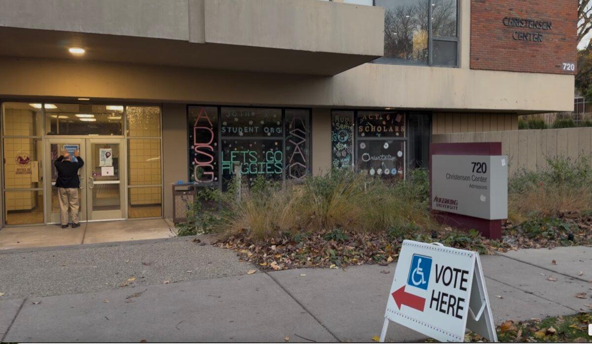 A worker puts up a sign at a polling site, Augsburg Univeristy's Christensen Center, in Ward 2, Precinct 7, in Minneapolis on Election Day, Nov. 4, 2025. (Janice Hisle/The Epoch Times)