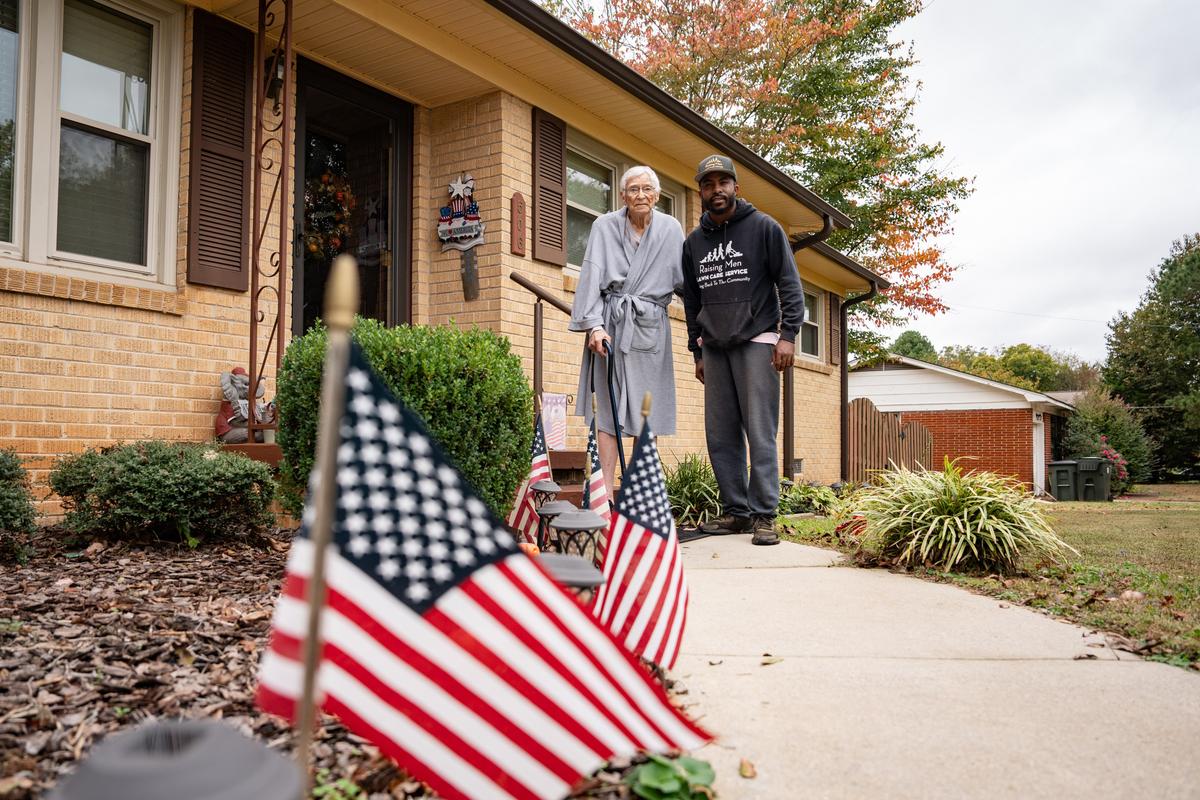 Rodney Smith Jr. (R) stands next to 90-year-old veteran James Smith, after mowing his lawn in Madison, Ala., on Oct. 28, 2025. (Samira Bouaou/The Epoch Times)