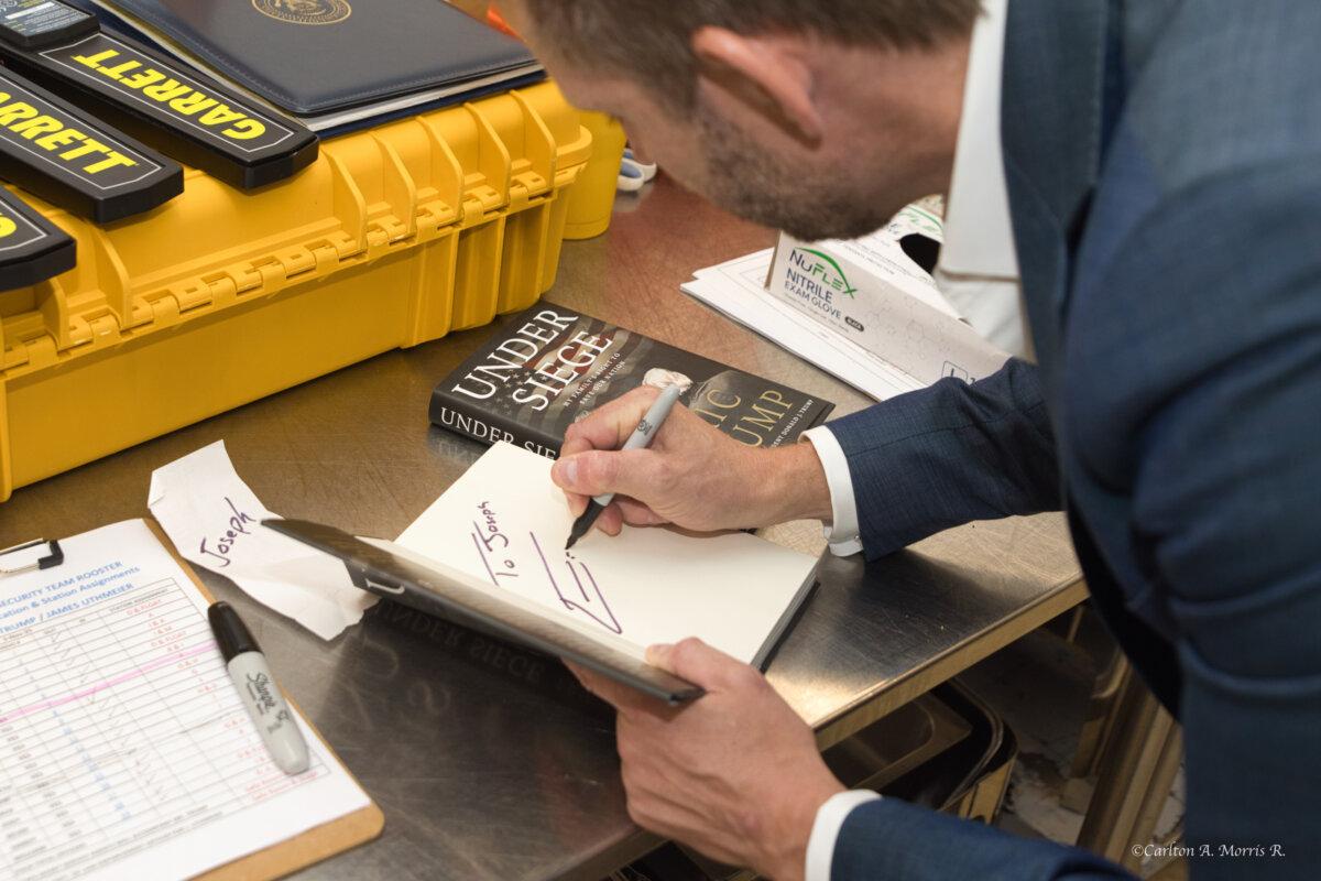 Eric Trump signs copies of his new book, 'Under Siege: My Family's Fight to Save Our Nation,' at Club 47 USA, a Trump fan club, in West Palm Beach, Fla., on Nov. 3, 2025. (Courtesy of Carlton A. Morris)