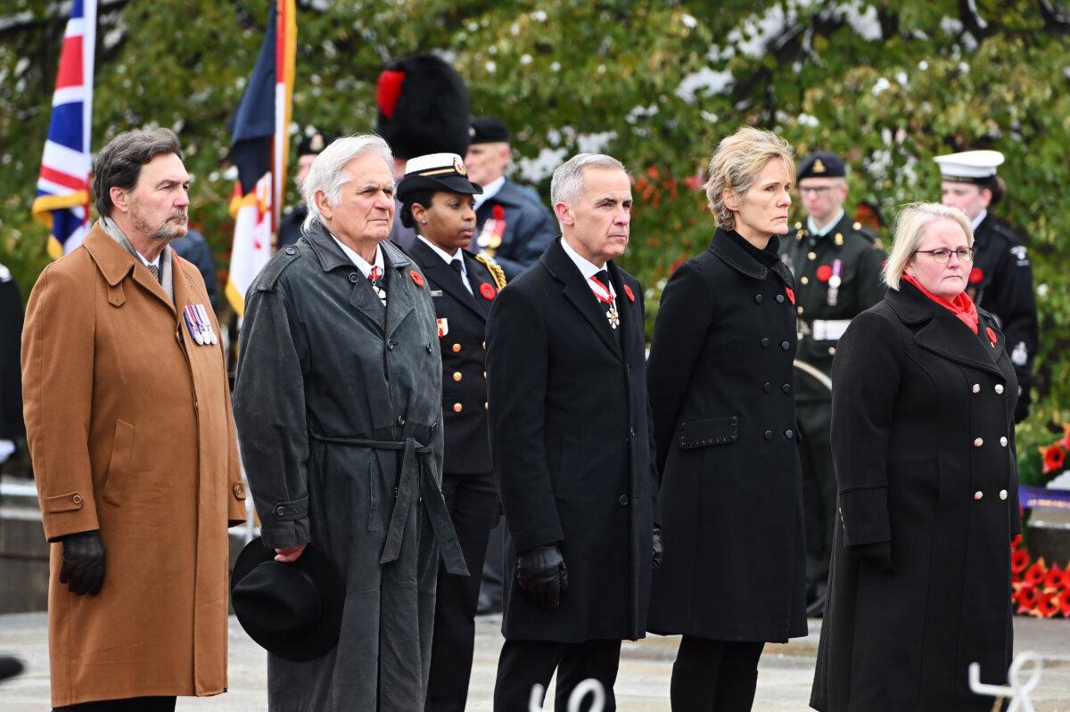 (L-R) Deputy of the Governor General and Chief Justice of Canada Richard Wagner, Whit Fraser, Prime Minister Mark Carney, wife Diana Fox Carney, and Minister of Veterans Affairs Jill McKnight look on during a Remembrance Day ceremony in Ottawa on Nov. 11, 2025. (The Canadian Press/Spencer Colby)