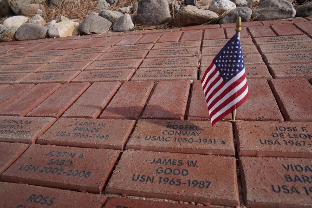 An American flag casts a shadow over commemorative bricks at the Vietnam Veterans Memorial in Angel Fire, N.M., on Nov. 11, 2025. (Allan Stein/The Epoch Times)