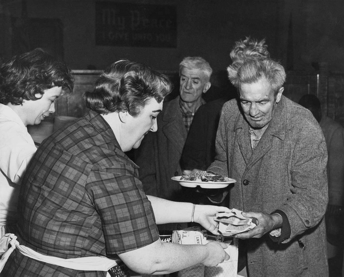 Members of the Volunteers of America serve Thanksgiving dinner to the homeless at Bowery Tabernacle in New York City, circa 1935. (Archive Photos/Getty Images)