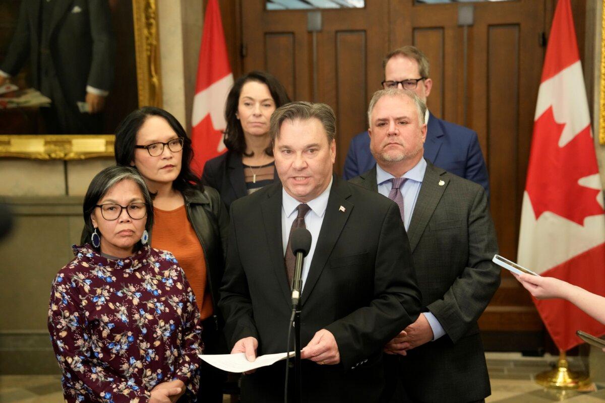 Interim NDP Leader Don Davies is surrounded by NDP MPs as he speaks at a press conference following a vote on the federal budget on Parliament Hill in Ottawa, on Nov. 17, 2025. (The Canadian Press/Adrian Wyld)
