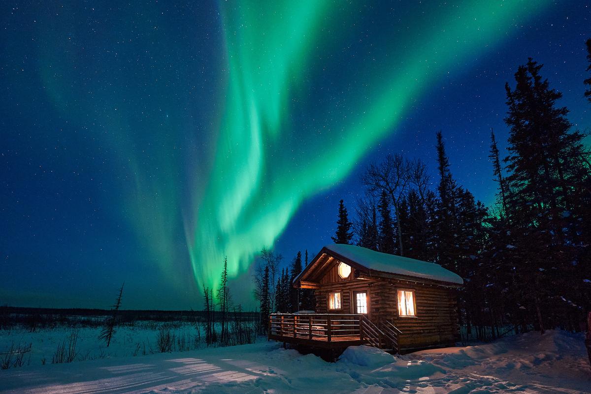 Aurora over a cabin in the forest. (Kyle Ledeboer/Ascent Xmedia/Getty Images)